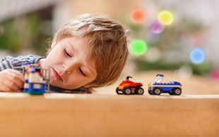 Little boy playing with car toys